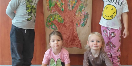 Powiększ grafikę: Czworo dzieci z grupy II pozuje do zdjęcia z drzewem jesiennym  - praca plastyczna dzieci
