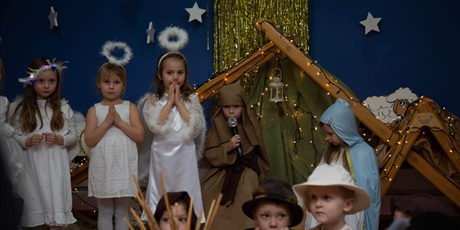 Powiększ grafikę: Jasełka przygotowane przez Kosmoludki. Na zdjęciu trzy dziewczynki w strojach aniołka, Józef i Maryja w szopce i trzech pastuszków.