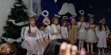 Powiększ grafikę: Jasełka przygotowane przez Kosmoludki. Na zdjęciu dziewczynki w strojach aniołków śpiewają kolędę