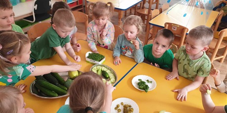 Powiększ grafikę: Dzieci z grupy II siedzą przy stolikach i zajadają ze smakiem zielone warzywka.