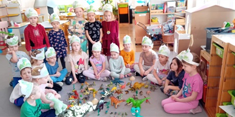 Powiększ grafikę: Dzień Dinozaura w grupie III - dzieci bawią się na dywanie figurkami dinozaurów