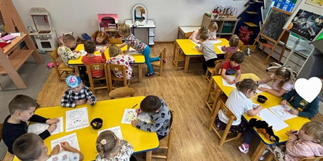 Powiększ grafikę: Dzieci z grupy II przy stolikach kolorują misie