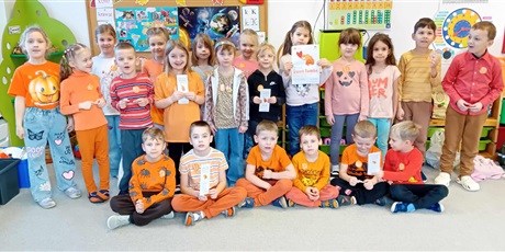 Powiększ grafikę: Ekoludki na zdjęciu ubrane na pomarańczowo