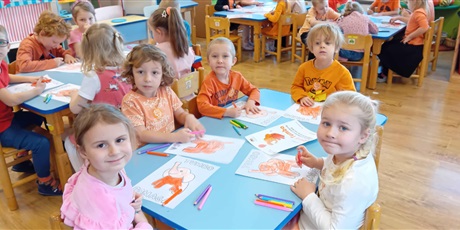 Powiększ grafikę: Dzieci przy stolikach kolorują Słonika Tumbo