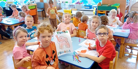Powiększ grafikę: Dzieci przy stolikach kolorują Słonika Tumbo
