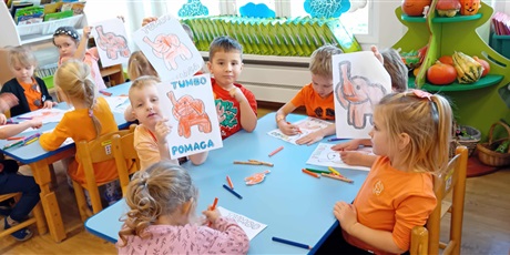 Powiększ grafikę: Dzieci przy stolikach kolorują Słonika Tumbo