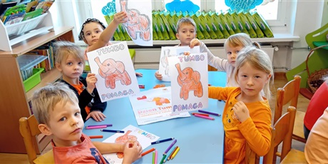Powiększ grafikę: Dzieci przy stolikach kolorują Słonika Tumbo