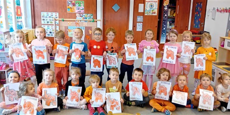 Powiększ grafikę: Kosmoludki na zdjęciu - dzieci trzymają w rączkach pokolorowanego Słonika Tumbo