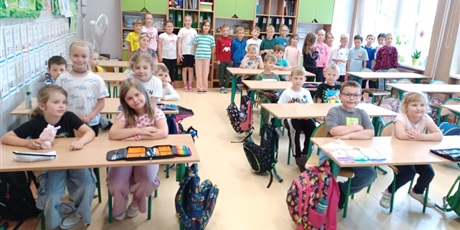 Powiększ grafikę: Ekoludki poznają salę lekcyjną, siedzą w ławkach i słuchają Pani
