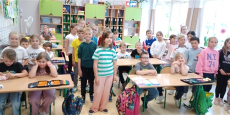 Powiększ grafikę: Ekoludki poznają salę lekcyjną, siedzą w ławkach i słuchają Pani
