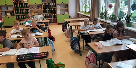 Powiększ grafikę: Ekoludki poznają salę lekcyjną, siedzą w ławkach 