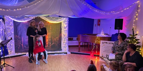 Powiększ grafikę: Rodzina biorąca udział w Festiwalu kolęd i pastorałek podczas wystepu