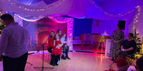 Powiększ grafikę: Rodzina biorąca udział w Festiwalu kolęd i pastorałek podczas wystepu