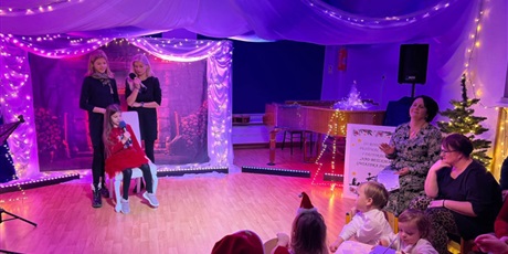 Powiększ grafikę: Rodzina biorąca udział w Festiwalu kolęd i pastorałek podczas wystepu