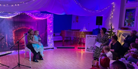 Powiększ grafikę: Rodzina biorąca udział w Festiwalu kolęd i pastorałek podczas wystepu