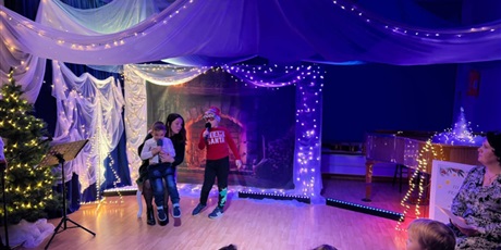 Powiększ grafikę: Rodzina biorąca udział w Festiwalu kolęd i pastorałek podczas występu