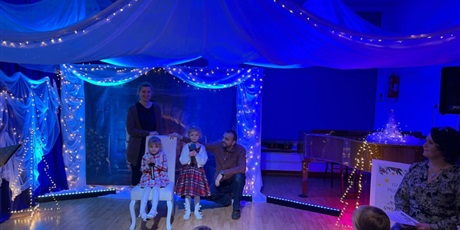 Powiększ grafikę: Rodzina biorąca udział w Festiwalu kolęd i pastorałek podczas występu