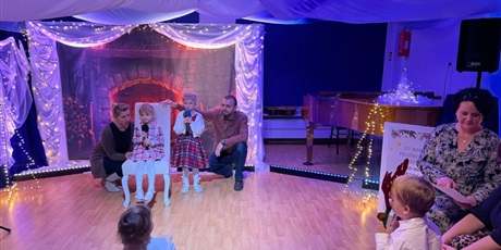 Powiększ grafikę: Rodzina biorąca udział w Festiwalu kolęd i pastorałek podczas występu