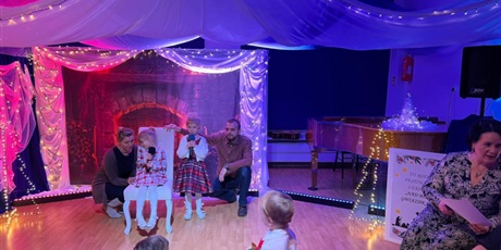 Powiększ grafikę: Rodzina biorąca udział w Festiwalu kolęd i pastorałek podczas występu