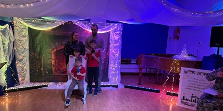 Powiększ grafikę: Rodzina biorąca udział w Festiwalu kolęd i pastorałek podczas występu