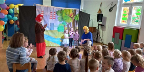 Powiększ grafikę: Na zdjęciu widownia, aktorzy i trzy dziewczynki biorące udział w przedstawieniu.