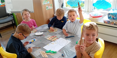 Powiększ grafikę: Światowy Dzień Drzewa - grupa III - dzieci przy stoliku robią pracę plastyczną; kolorują, wyklejają, wycinają drzewo