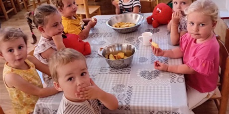 Powiększ grafikę: Dzieci z grupy I siedzą przy stoliku i jedzą pyszne, zdrowe jabłka
