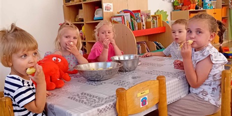 Powiększ grafikę: Dzieci z grupy I siedzą przy stoliku i jedzą pyszne, zdrowe jabłka
