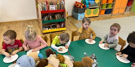 Powiększ grafikę: Dzieci siedzą przy stoliku i wykonują samodzielnie misie z talerzyków jednorazowych.