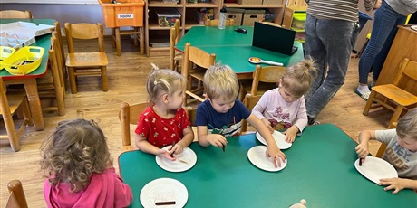Powiększ grafikę: Dzieci siedzą przy stoliku i wykonują samodzielnie misie z talerzyków jednorazowych.