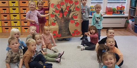 Powiększ grafikę: Święto Jabłka w grupie I. Dzieci prezentują piękną jabłoń z przyklejonymi jabłuszkami.