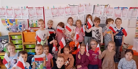 Powiększ grafikę: Dzieci z grupy IV pozują do zdjęcia trzymając w ręce flagę Polski