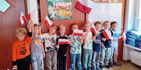 Powiększ grafikę: Chłopcy z grupy IV pozują do zdjęcia trzymając w ręce flagę Polski