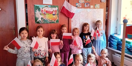 Powiększ grafikę: Dziewczynki z grupy IV pozują do zdjęcia trzymając w ręce flagę Polski