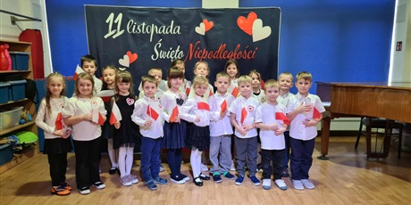 Powiększ grafikę: Ekoludki podczas Dnia Niepodległości ubrane odświętnie trzymają w rączkach flagi Polski