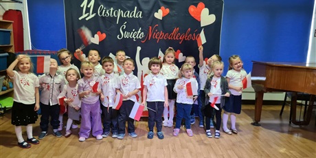 Powiększ grafikę: Bajkoludki podczas Dnia Niepodległości ubrane odświętnie trzymają w rączkach flagi Polski