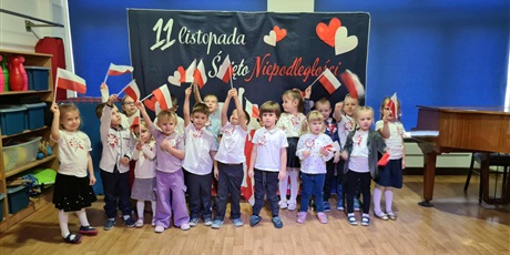 Powiększ grafikę: Bajkoludki podczas Dnia Niepodległości ubrane odświętnie trzymają w rączkach flagi Polski