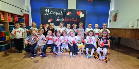 Powiększ grafikę: Kosmoludki podczas Dnia Niepodległości ubrane odświętnie trzymają w rączkach flagi Polski