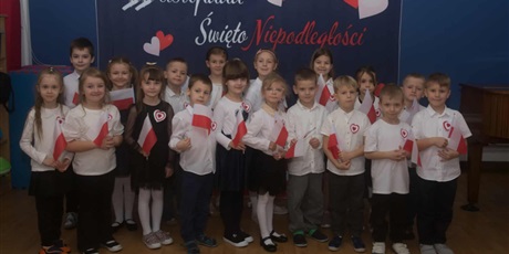 Powiększ grafikę: Na zdjęciu Ekoludki w strojach galowych; dzieci trzymają w rękach flagi Polski