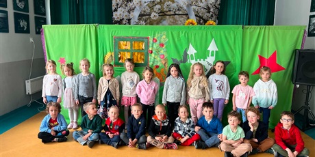 Powiększ grafikę: Grupa III w Maciusiu pozuje do zdjęcia; w tle dekoracja do przedstawienia