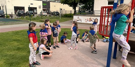 Powiększ grafikę: Na zdjęciu grupa dzieci wykonuje zadania sportowe
