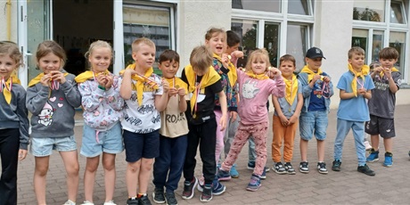 Powiększ grafikę: Na zdjęciu grupa dzieci w żółtych chustach czeka na zadanie sportowe