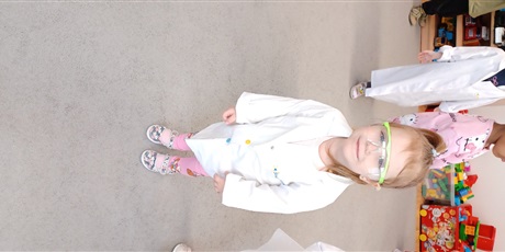 Powiększ grafikę: Dziecko z grupy I w białym fartuchu podczas zajęć chemicznych