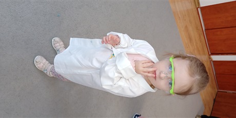 Powiększ grafikę: Dziecko z grupy I w białym fartuchu podczas zajęć chemicznych