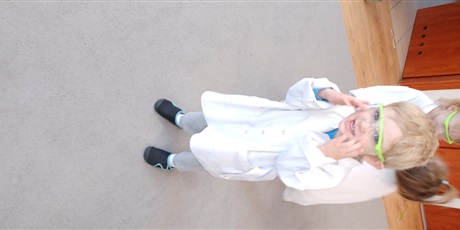 Powiększ grafikę: Dziecko z grupy I w białym fartuchu podczas zajęć chemicznych