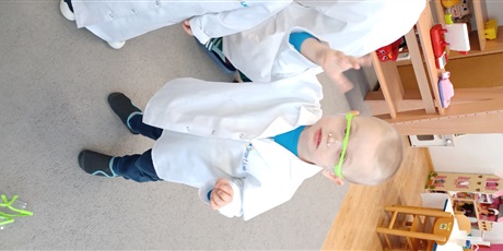 Powiększ grafikę: Dziecko z grupy I w białym fartuchu podczas zajęć chemicznych