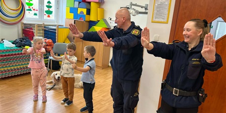 Powiększ grafikę: Dzieci, pracownicy Straży Miejskiej i pies Marley na sali gimnastycznej podczas zajęć edukacyjnych
