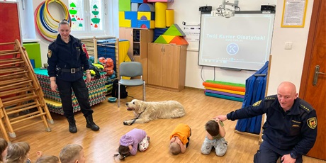 Powiększ grafikę: Dzieci, pracownicy Straży Miejskiej i pies Marley na sali gimnastycznej podczas zajęć edukacyjnych