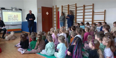 Powiększ grafikę: Dzieci, pracownicy Straży Miejskiej i pies Marley na sali gimnastycznej podczas zajęć edukacyjnych