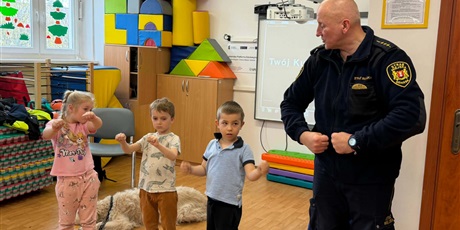 Powiększ grafikę: Dzieci, pracownicy Straży Miejskiej i pies Marley na sali gimnastycznej podczas zajęć edukacyjnych